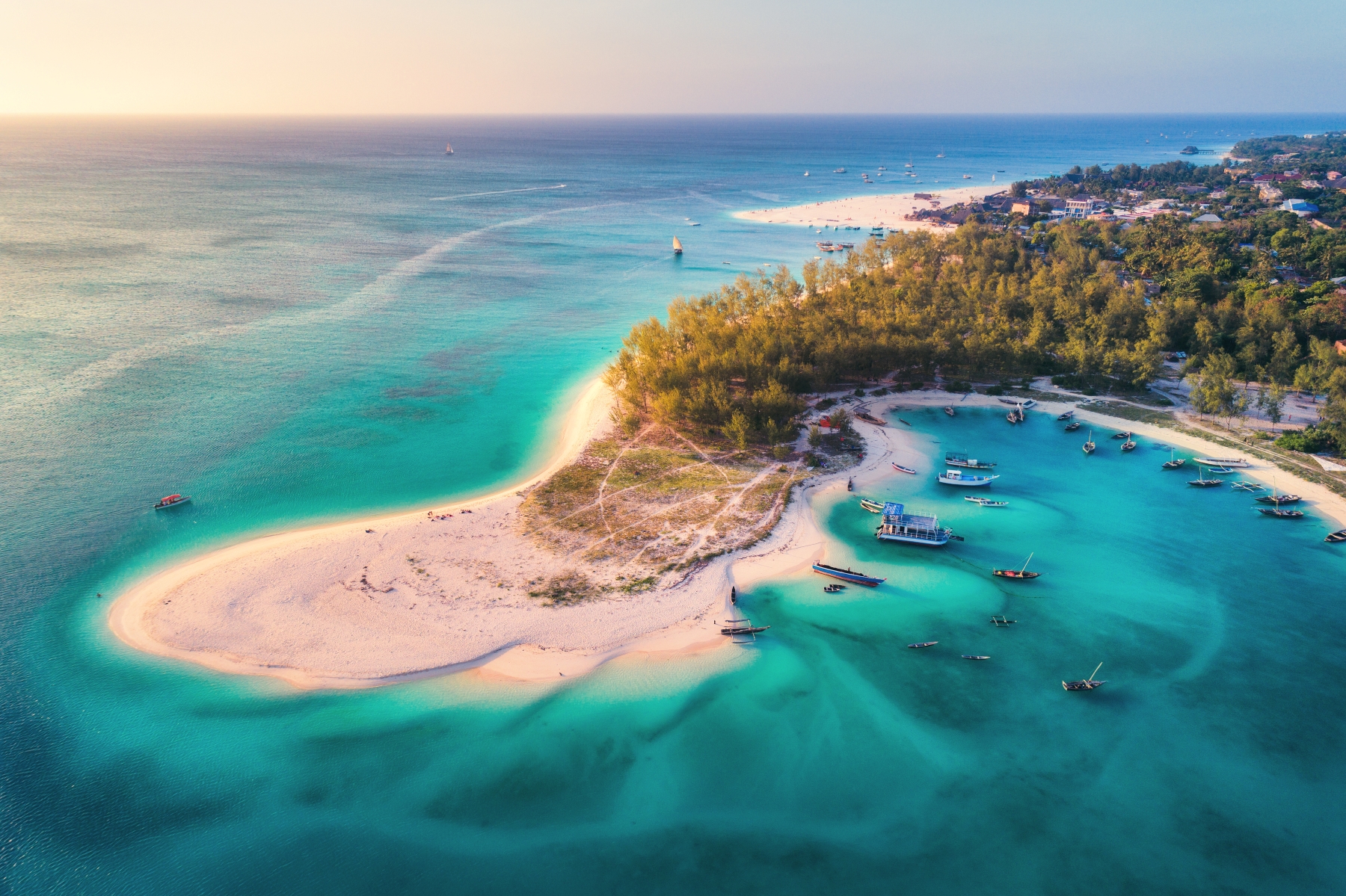 Zanzibar-257256800 An aerial view of a white-sand peninsula surrounded by turquoise water and moored boats off the coast of Zanzibar